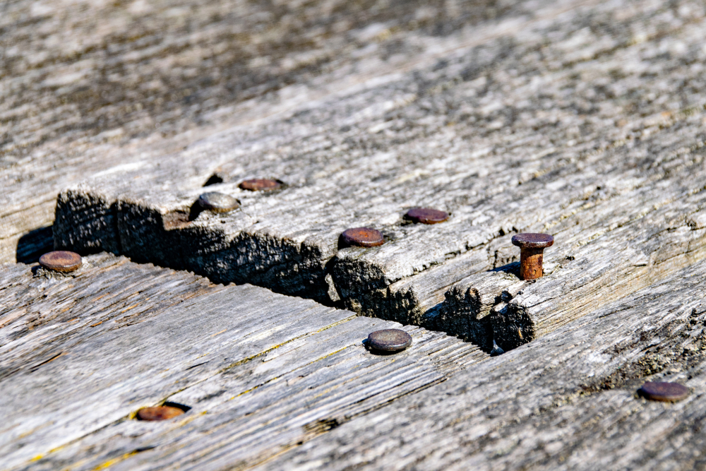 Rusty nails and raised wood decking panels